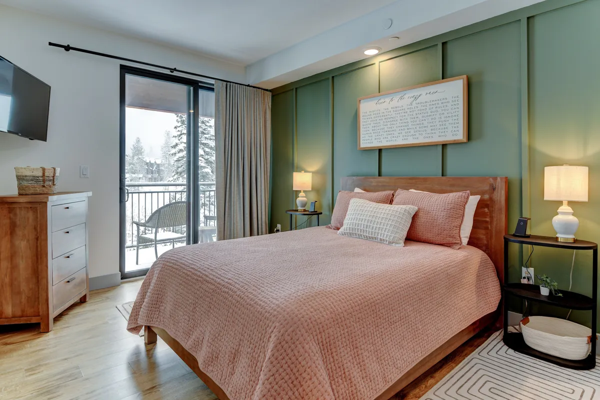 A welcoming guest bedroom with a comfortable bed, a window allowing natural light to filter in, a nightstand with a lamp, and tasteful artwork. The space feels inviting and relaxed, ideal for restful nights and peaceful mornings.