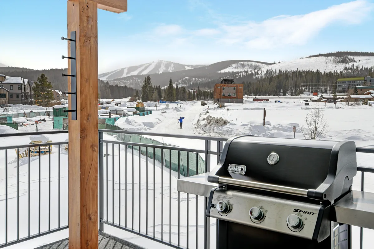 Features a snow-covered patio with a grill, mountain views, and space for outdoor gatherings. The inviting exterior hints at relaxation after a day of adventure or enjoying morning coffee while planning the day's exploits.